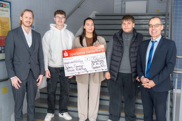 Foto: Bildtext: <br />Justin Weißenberger und Daniel Klewzow (2.v.l. u. 2.v.r.) nahmen für die Schülerschaft die Spende der Sparkasse Heidelberg entgegen, die Regionalleiter Sascha Lindenblatt (l.) und Filialleiterin Canan Erdogmus (m.) in Gegenwart von Schulleiter Uli Richard Liebler (r.) übergaben. 